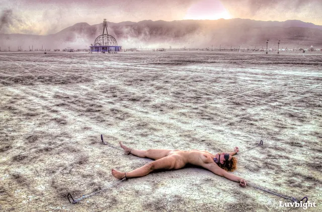 "Martian Sacrifice". This was the last photo I took of Dee chained to the playa at Burning Man 2004. A dust storm arose from the northwest, and you can see the clouds rushing to engulf her.