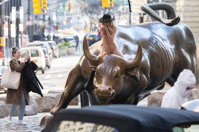 Nude woman ignores coronavirus warnings to straddle ‘Charging Bull’