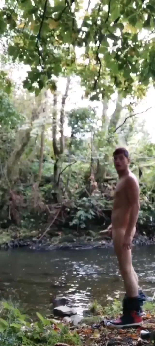 Hard dude pissing into the creek